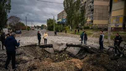 Жители смотрят на воронку, образовавшуюся после ракетного удара по Днепру, 10 октября.<br />
<br />
Президент России Владимир Путин назвал ракетные удары &laquo;ответом&raquo; на взрыв на Крымском мосту 8 октября. Мост соединяет Россию с аннексированным в 2014 году полуостровом Крым&nbsp;